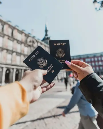Two passports held in a hand